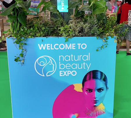 Empty Salt of the Earth natural deodorant exhibition stand F20 at Natural Beauty Expo before setup, showing the white shell scheme booth with blue branded header panels.