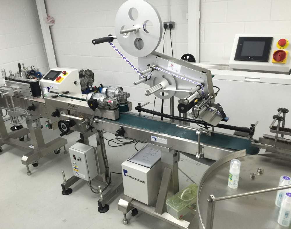Labelling machine on Salt of the Earth deodorant production line applying product labels in a clean factory setting